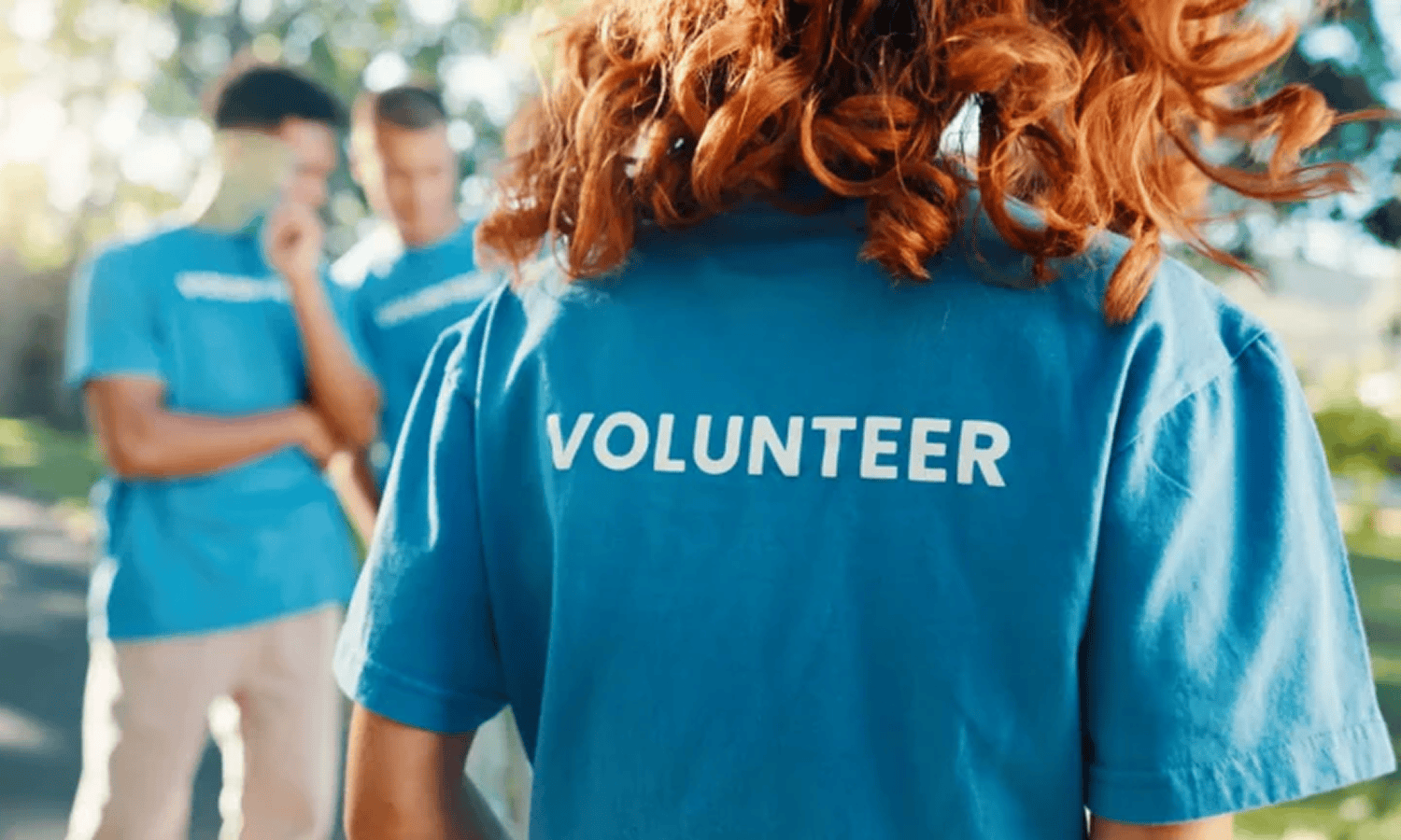 Volunteer in blue shirt at outdoor event.